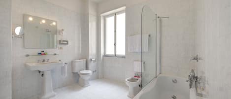 A modern bathroom with a sink, toilet, and bathtub.