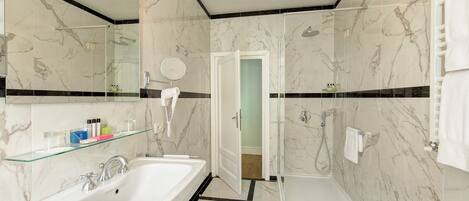 A modern bathroom with a large white sink, a glass shower enclosure, and a separate bathtub.