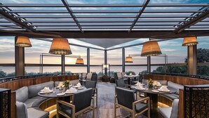 A restaurant with a glass ceiling, wooden furniture, and tables set for dining. - Renaissance Polat Istanbul Hotel (Istanbul)