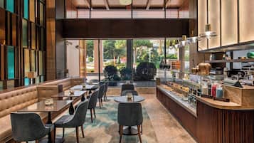 Ein modernes Restaurant mit Bar, Sitzgelegenheiten und Blick ins Freie.