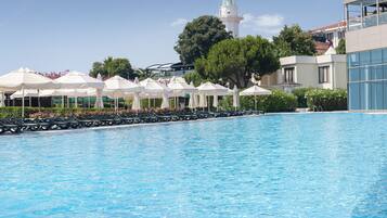 Una piscina techada, una piscina al aire libre de temporada, sombrillas
