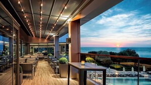 A modern lounge area with a wooden floor, seating, and a poolside view. - Renaissance Polat Istanbul Hotel (Istanbul)