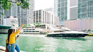 A waterfront view with a modern building and a yacht docked nearby.