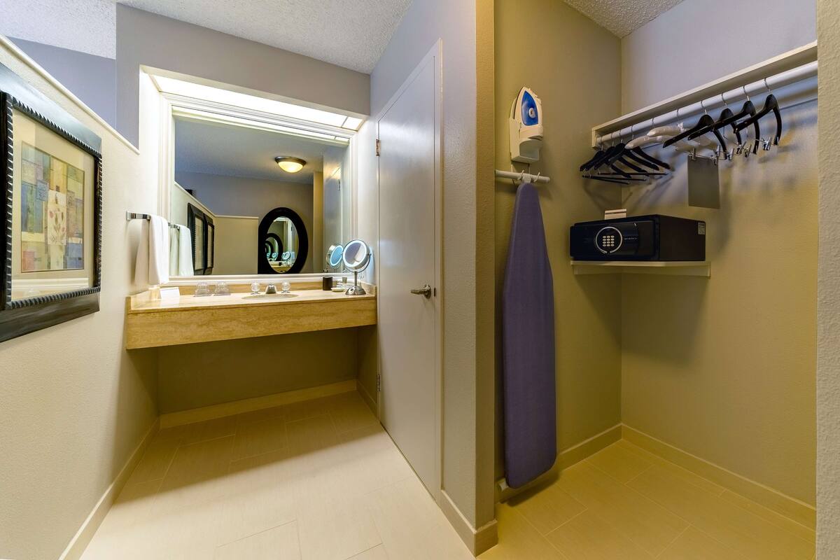 A bathroom with a vanity, mirror, and towel rack.