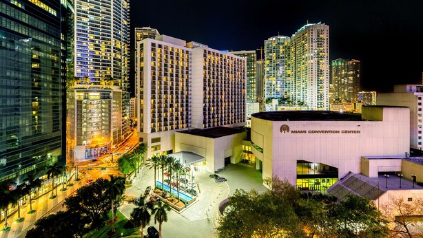 Un hotel de diseño moderno, con un edificio amplio de varios pisos y una entrada destacada.