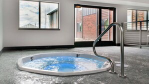 A 3ft hot tub in a room with large windows and a view of a brick building. - Copper King Convention Center, an Ascend Collection Hotel (Butte)