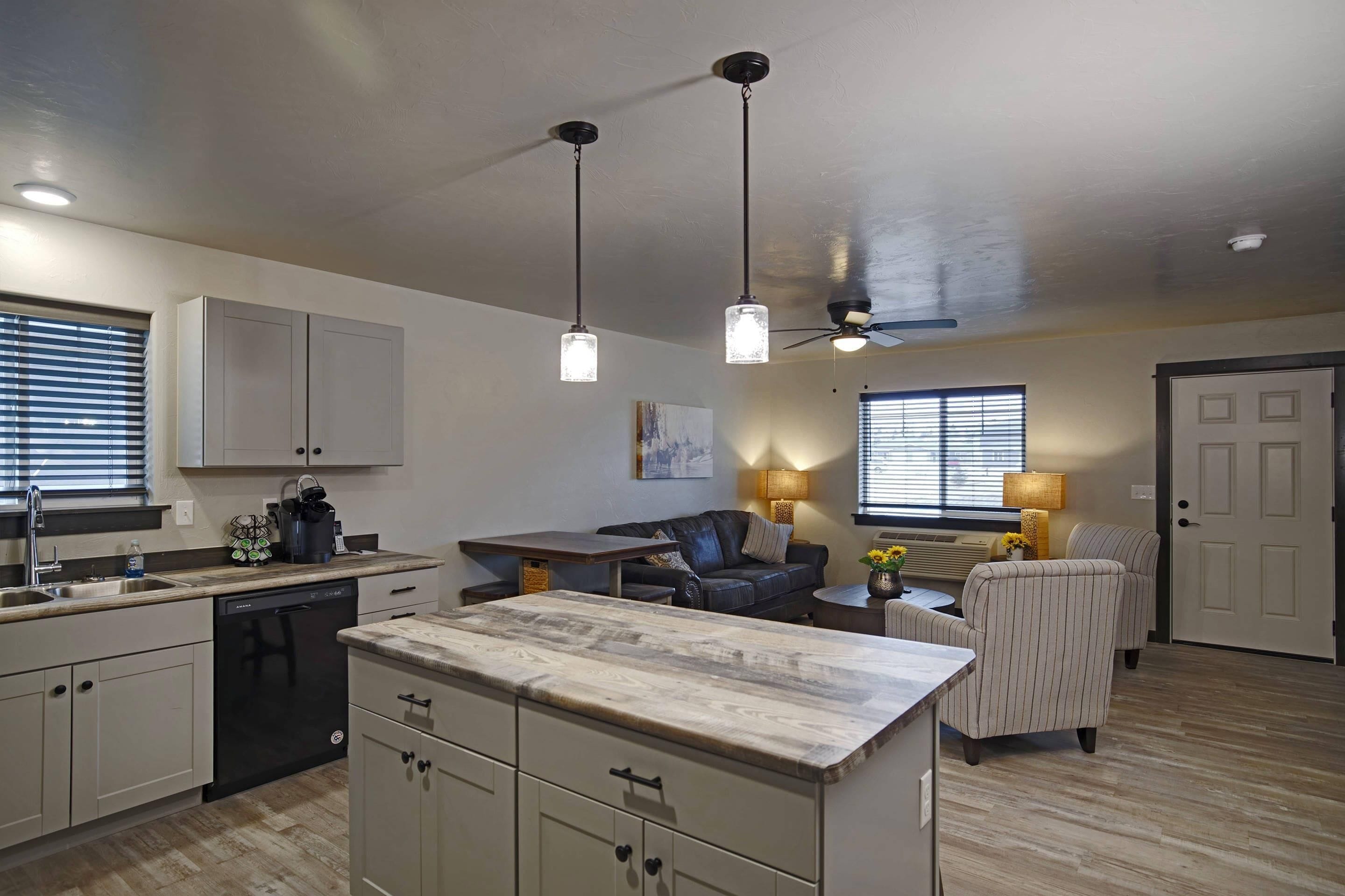 A modern kitchen with a central island, built-in cabinets, and pendant lighting.