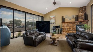 A spacious living room with leather sofas, a fireplace, and large windows offering a view of the street. - Quality Inn Richfield I-70 (Richfield)