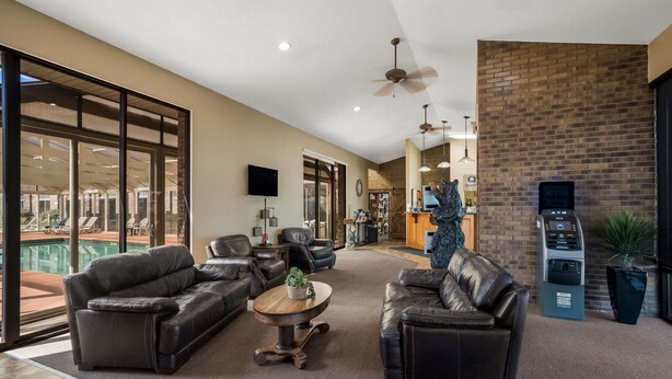 A spacious living area with leather sofas, a coffee table, and a view of a pool. - Quality Inn Richfield I-70 (Richfield)