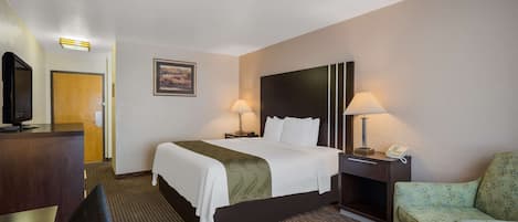 A hotel room with a bed, two bedside lamps, a desk with a telephone, a television, and a chair.