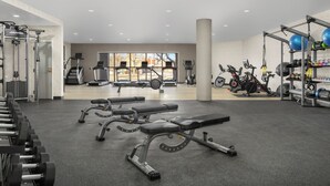 A gym with exercise equipment, benches, and a view of the outside. - DoubleTree by Hilton Salisbury (Salisbury)