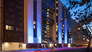 A modern hotel with a prominent 'W' sign, large windows, and a well-lit facade.