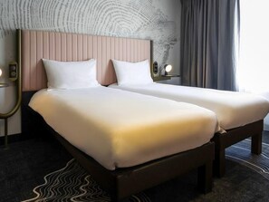 A double bed with a wooden frame and a headboard with vertical slats. - ibis Styles Paris Porte de Versailles - Mairie d'Issy (Issy-les-Moulineaux)
