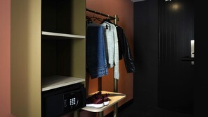 A hotel room with a built-in wardrobe, a small table with shoes, and a door. - ibis Styles Paris Porte de Versailles - Mairie d'Issy (Issy-les-Moulineaux)
