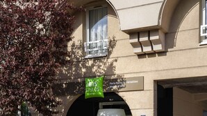A building with a sign for 'ibis Styles Hotels' and a location sign for 'Paris Porte de Versailles Mairie d'Issy.' - ibis Styles Paris Porte de Versailles - Mairie d'Issy (Issy-les-Moulineaux)