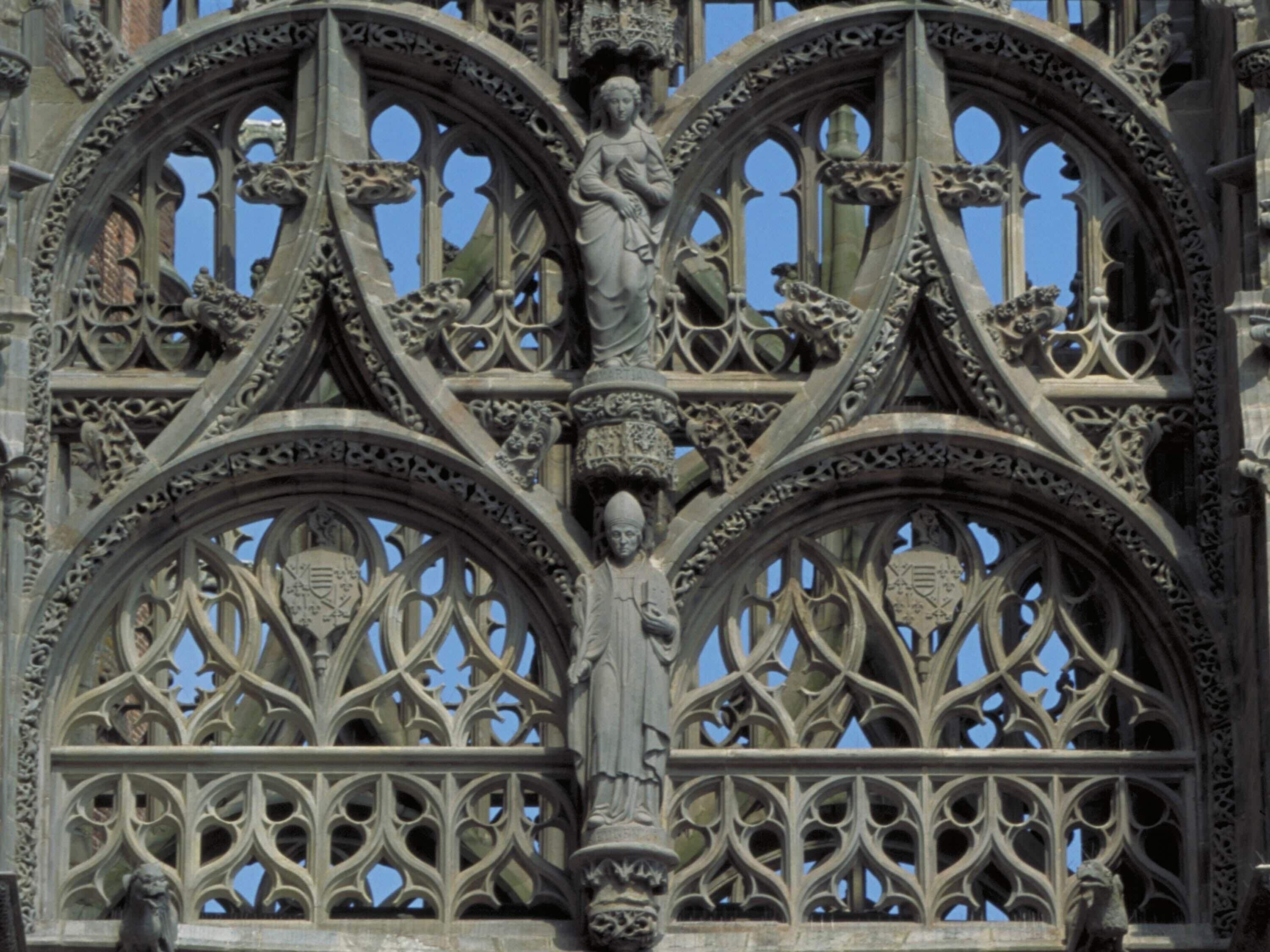Una façana de pedra detallada amb treballs de talla intricats i una estàtua central.