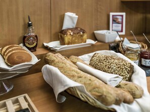 A breakfast table with pancakes, bread, and condiments.