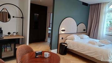 Une chambre d’hôtel équipée d’un lit, d’un bureau, d’une chaise, d’une table basse et d’une poubelle.