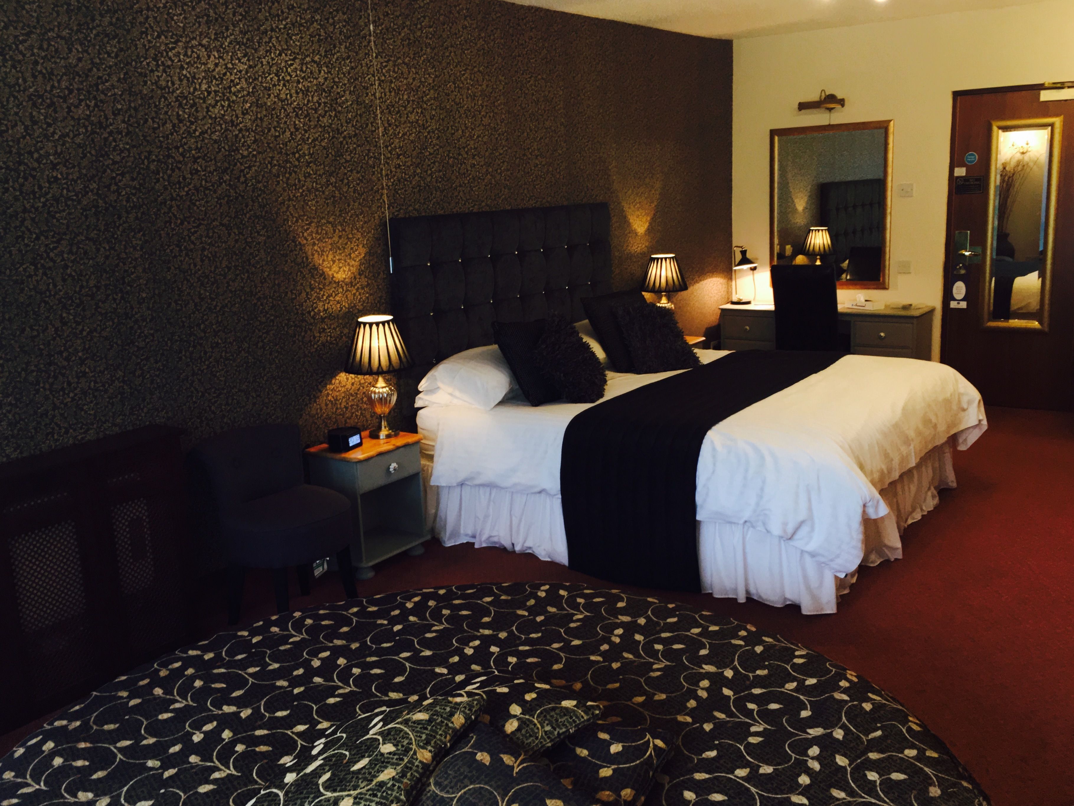 Ein Hotelzimmer mit zwei Betten, einem großen Spiegel und einem roten Teppich.