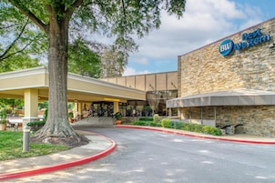 Un hotel Best Western con fachada de piedra, un acceso cubierto y un estacionamiento.