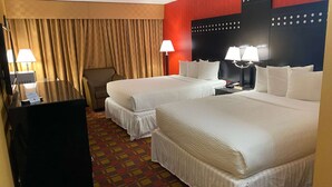 A hotel room with two beds, a desk, a chair, and a television. - Ramada by Wyndham Rochelle Park Near Paramus (Rochelle Park)