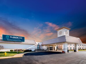 A hotel with a prominent clock tower, a conference center, and a clear sky.