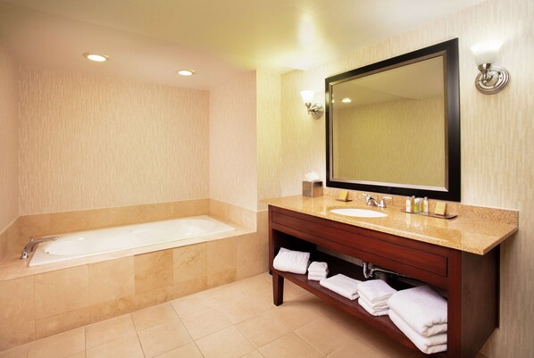 A modern bathroom with a bathtub, a sink, and a vanity.