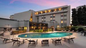 A hotel with a swimming pool, outdoor seating, and a modern architectural design. - Doubletree by Hilton Columbia, SC (Columbia)