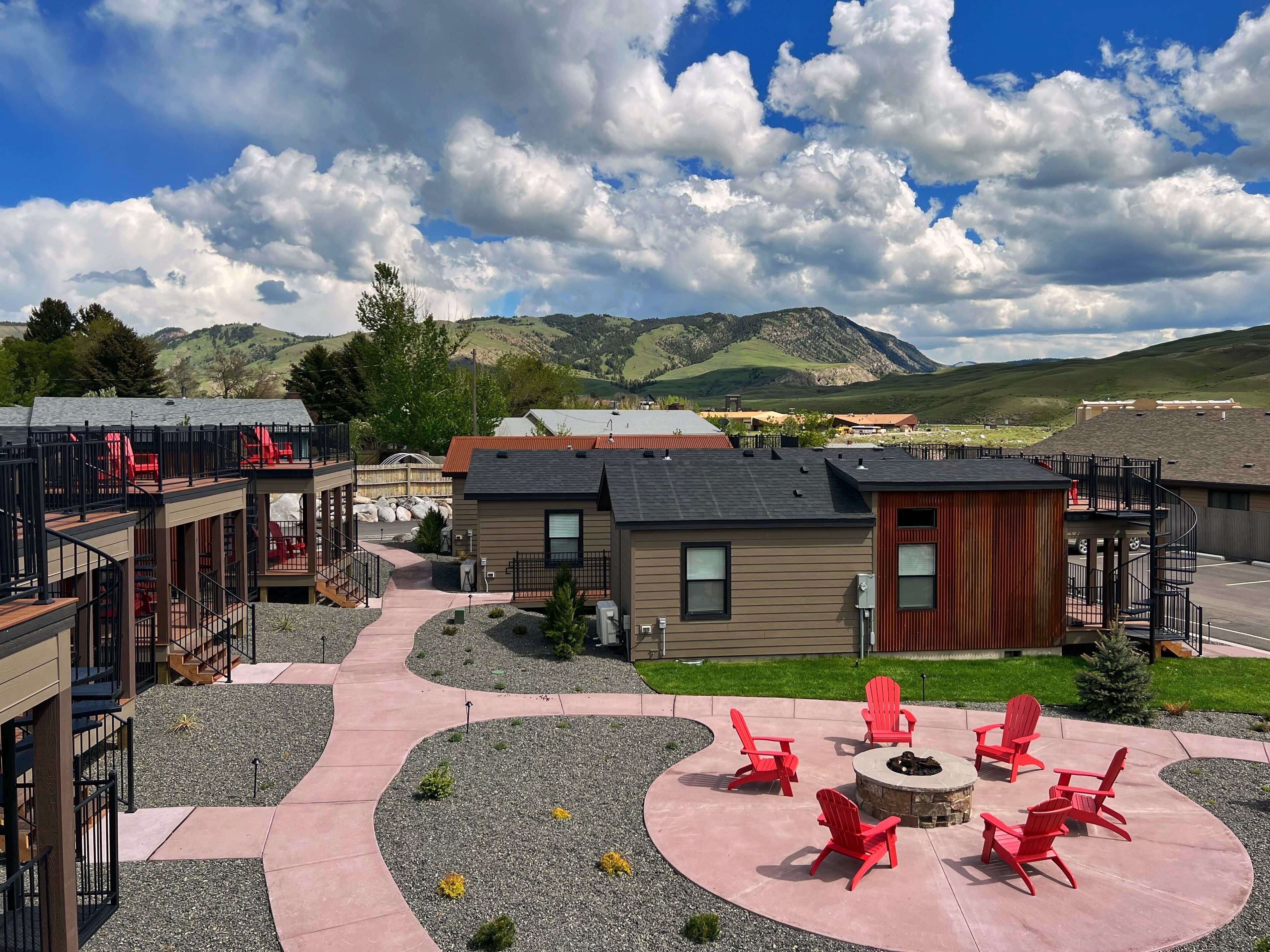 A residential area with a modern house, outdoor seating area, and a view of mountains.