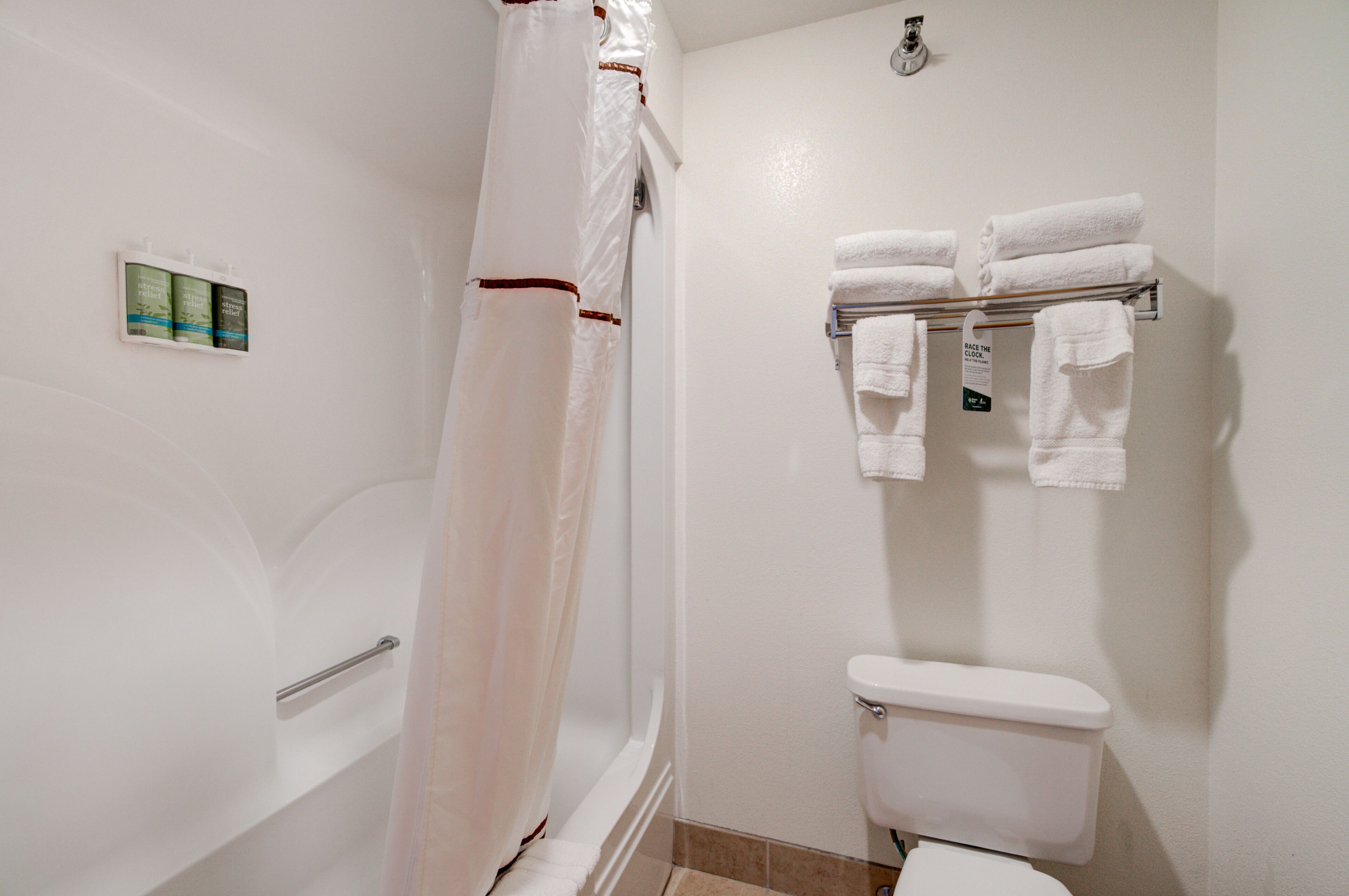 Un baño con bañera, inodoro y perchero para toallas.