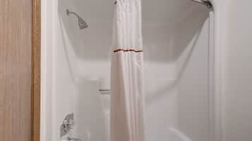 Ducha con cortina blanca y cabezal de ducha cromado.
