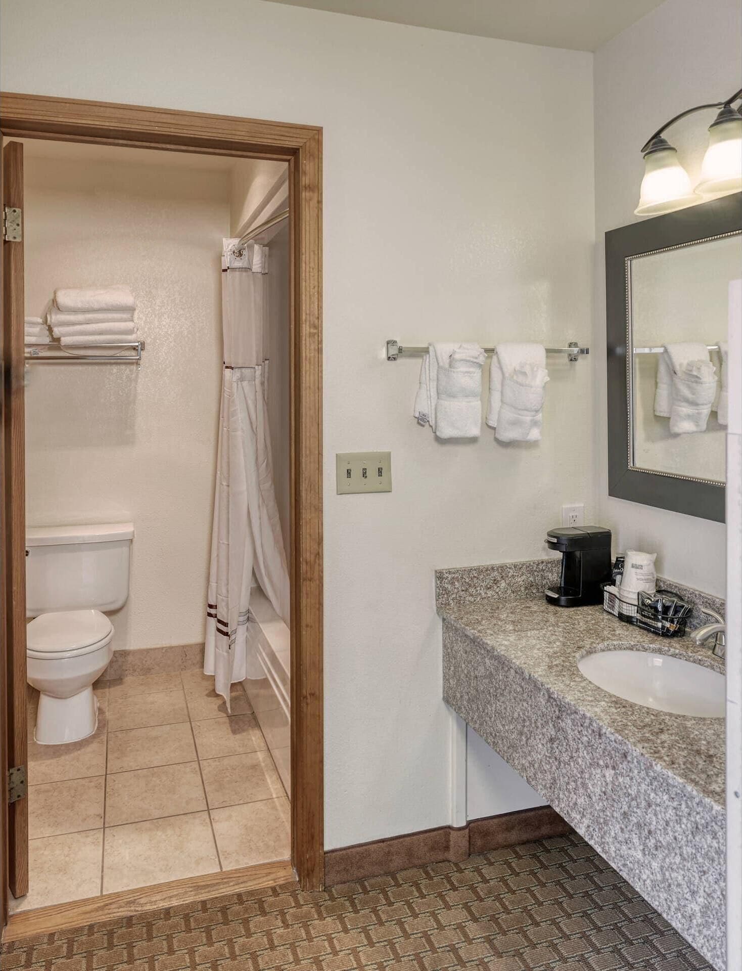 A bathroom with a toilet, shower, and sink.
