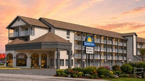 A Days Inn hotel with a modern architectural design, featuring a prominent entrance, multiple balconies, and a landscaped front garden.