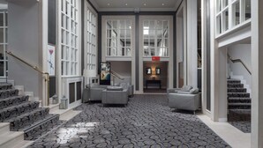A spacious lobby with patterned carpet, a staircase, and seating areas. - Park Inn by Radisson Shannon Airport (Shannon)