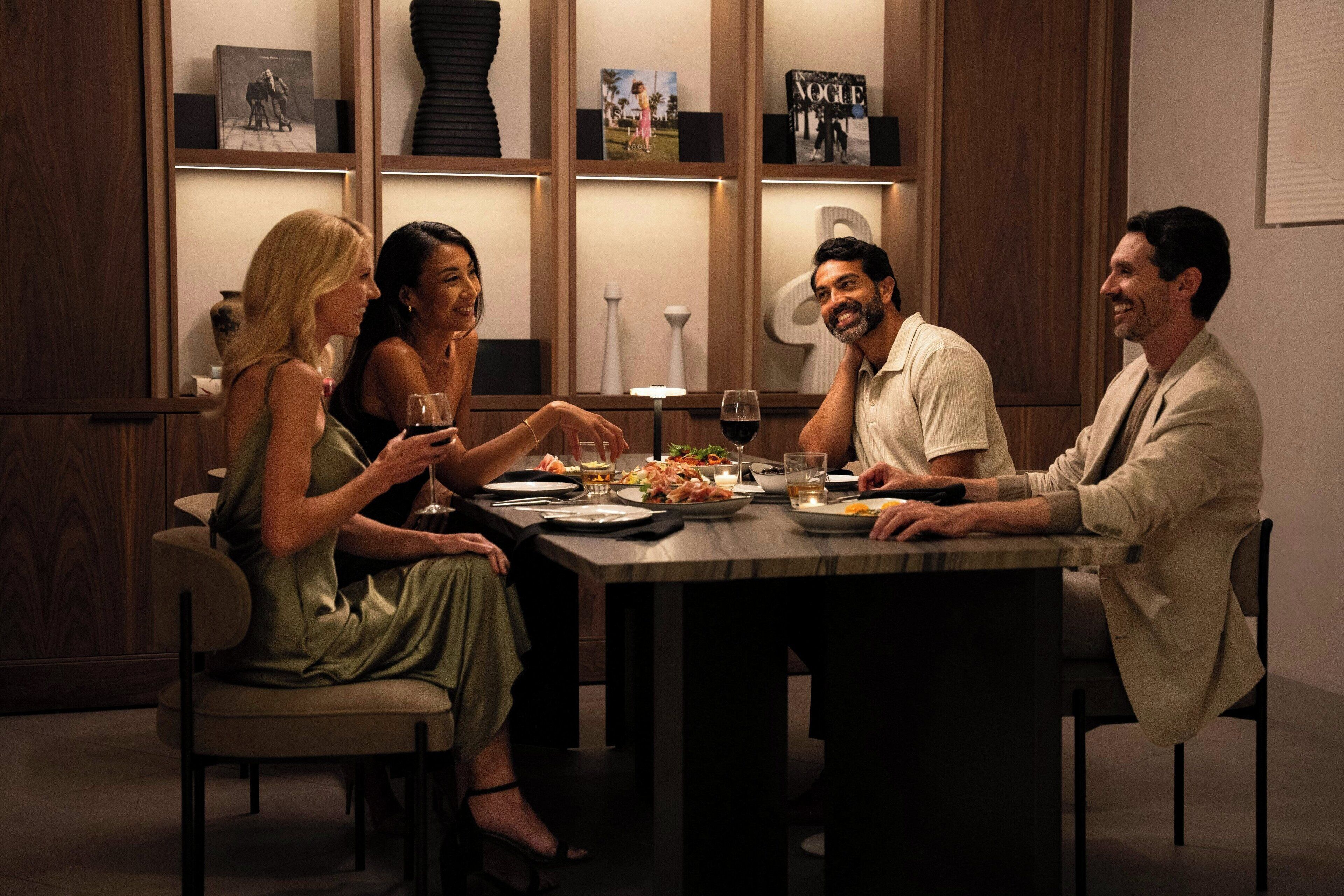 Un comedor con una mesa de mármol, sillas y una estantería al fondo.
