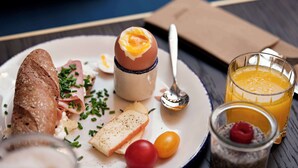 A breakfast plate with toast, eggs, cheese, and cherry tomatoes.