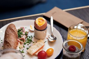 A breakfast plate with toast, eggs, cheese, and cherry tomatoes.