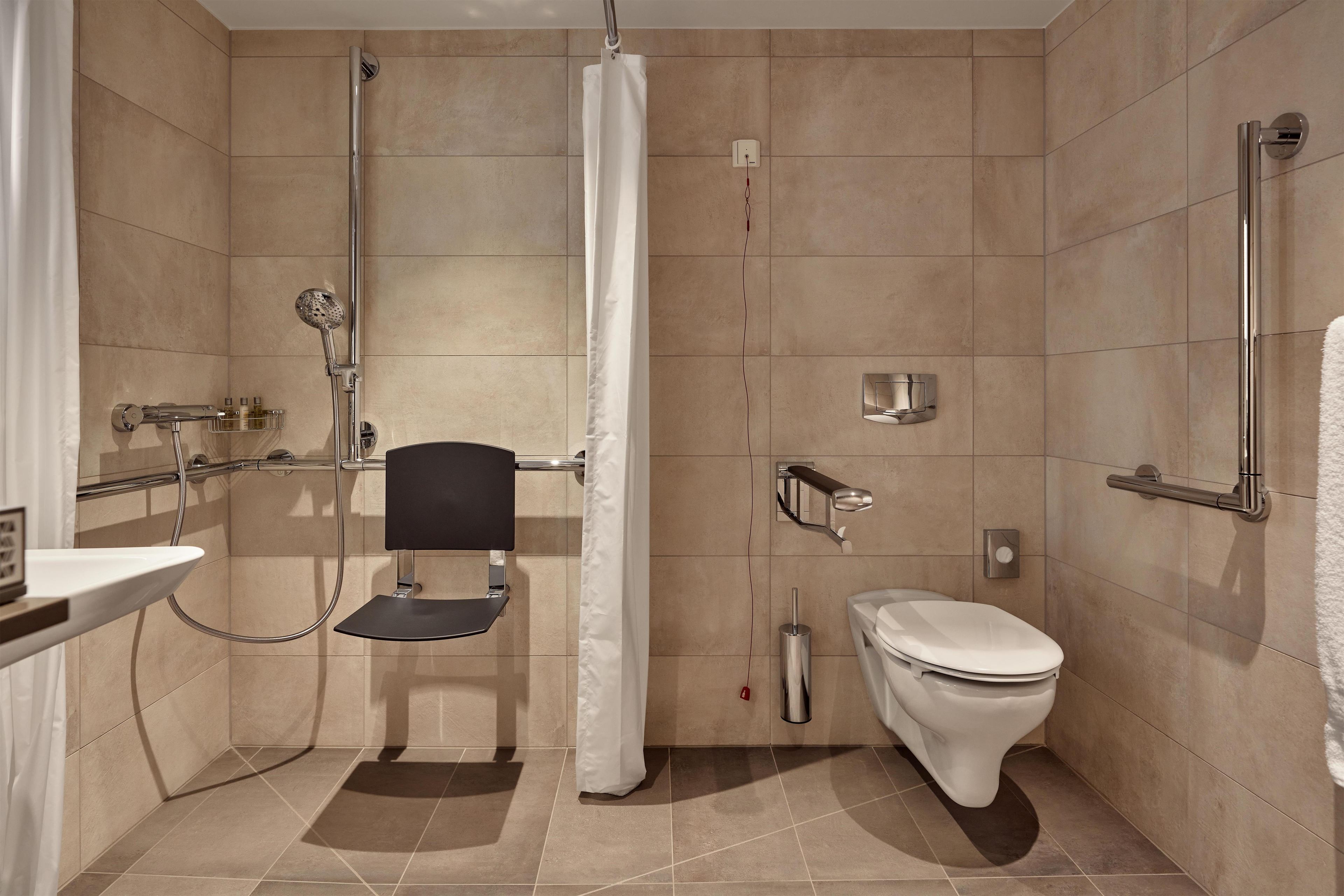 A modern bathroom with a shower, toilet, and sink.