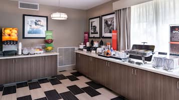 Una cocina moderna con piso a cuadros, un dispensador de jugo y una mesa de buffet.