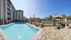 A swimming pool with a tiled deck, lounge chairs, and a pergola. - Hampton Inn Los AngelesWest Covina (West Covina)