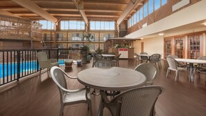 A spacious indoor area with a pool, multiple dining tables and chairs, and a kitchen area. - Quality Inn Chickasha (Chickasha)