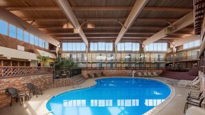 An indoor swimming pool with a wooden ceiling, brick walls, and multiple levels with balconies. - Quality Inn Chickasha (Chickasha)