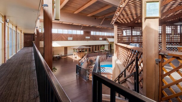 A spacious indoor area with wooden beams and a central pool. - Quality Inn Chickasha (Chickasha)