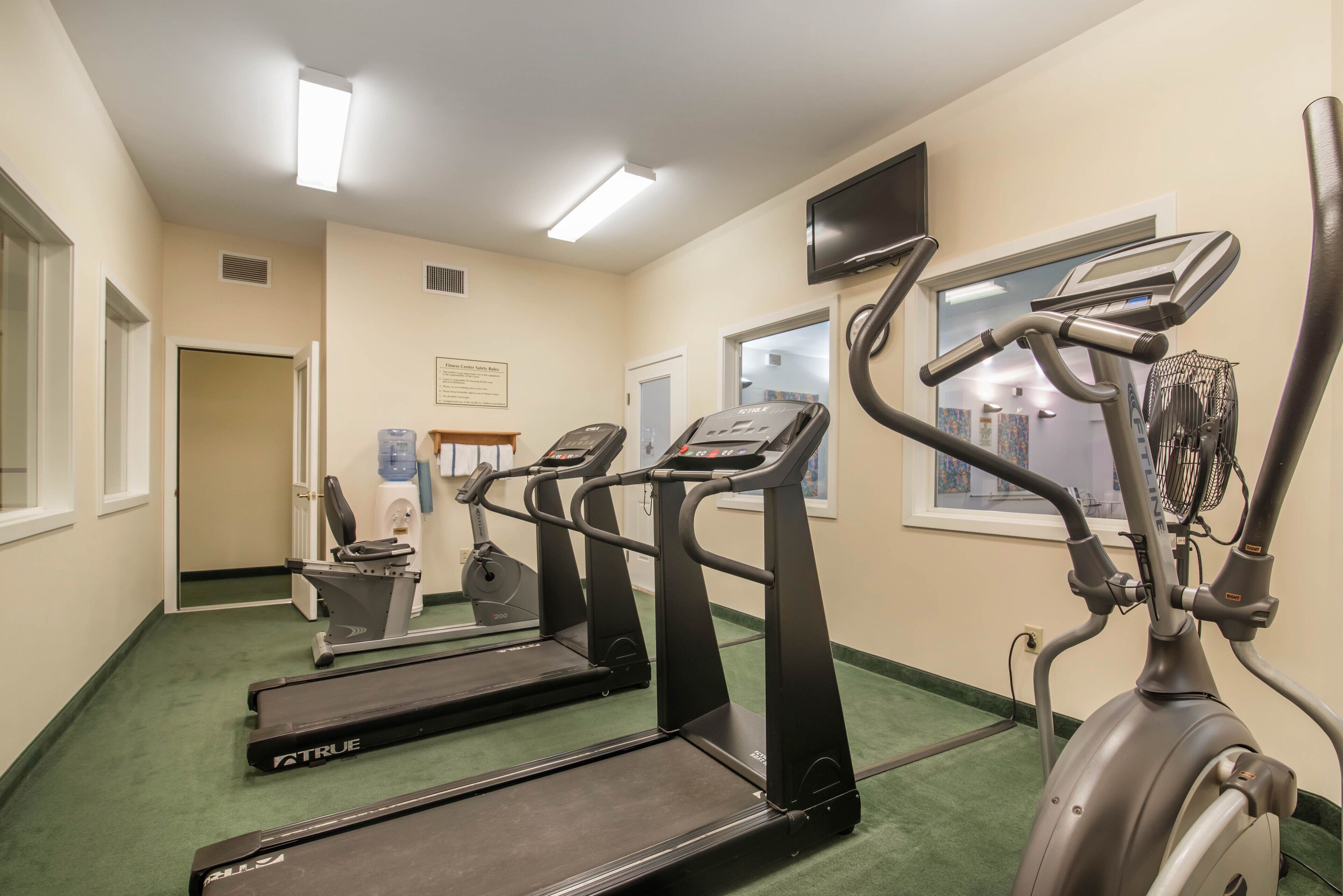 Ein Fitnessraum mit Laufbändern und einem Crosstrainer.