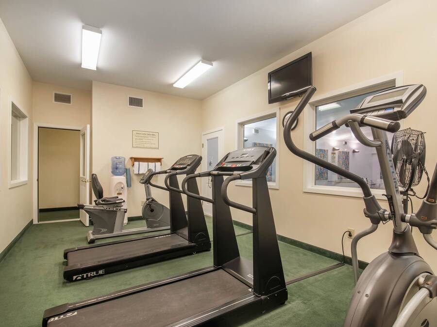 A fitness room with treadmills and an elliptical machine.