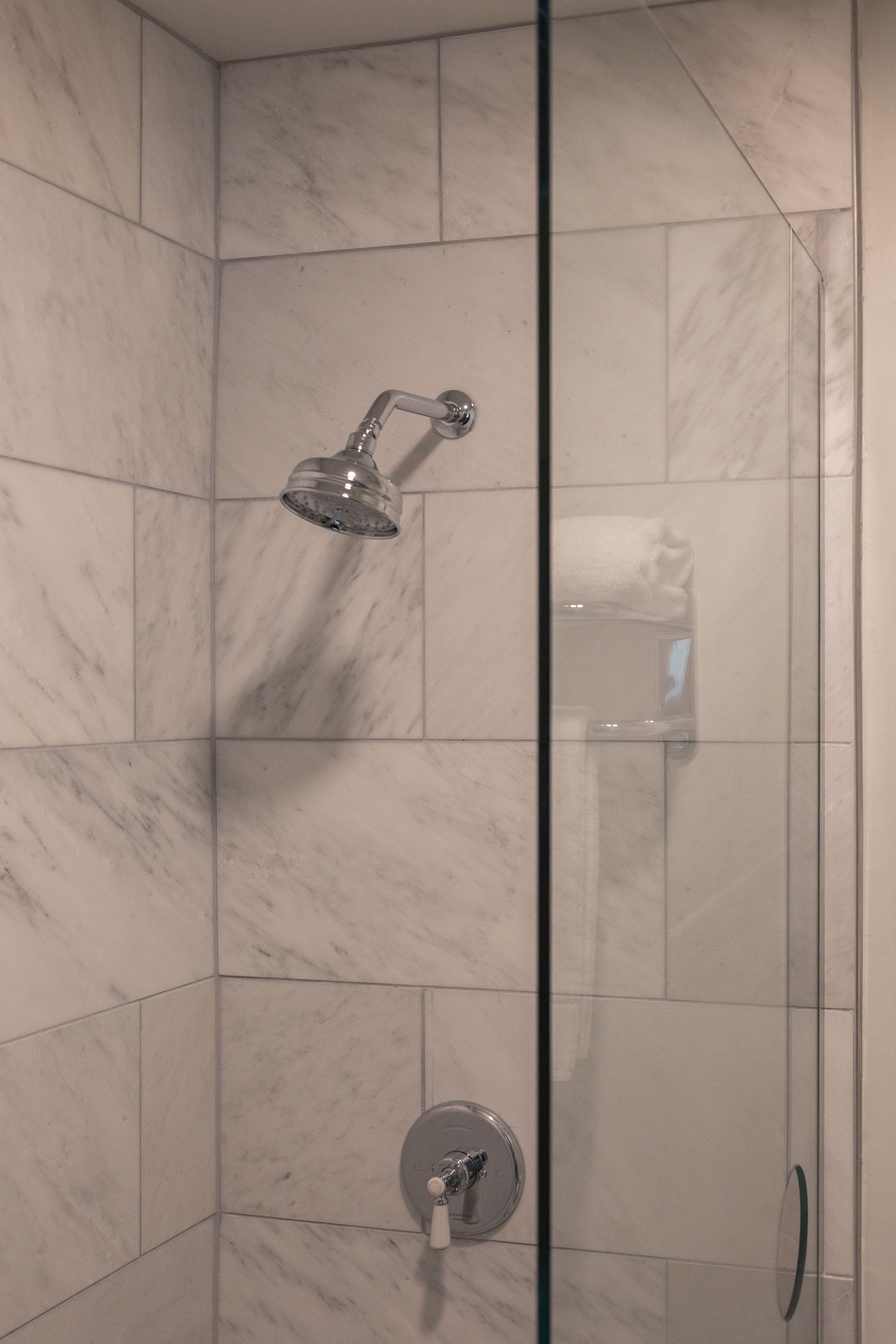 Eine Duschkabine mit Handbrause und ein fest installiertem Wasserhahn.