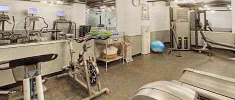 Un consultorio médico con diverso equipo, una cinta de correr y una pelota.