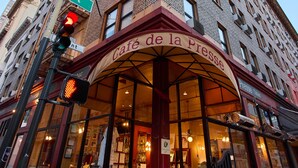 A building with a café named Café de la Presse, a street sign for Grant Street, and a neon sign for TRIP 10. - Hotel Triton Union Square San Francisco (San Francisco)