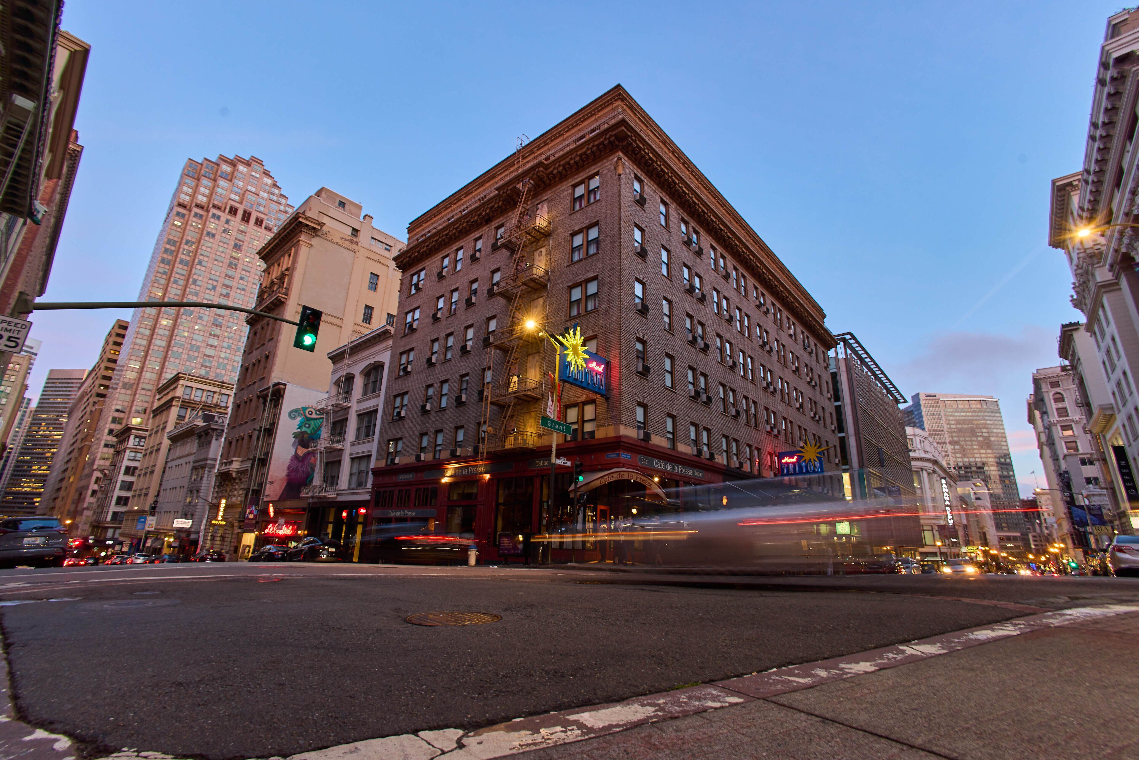 A multi-story building with a fire escape, large windows, and a visible storefront.