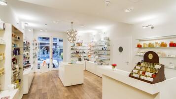 Una boutique moderna y bien iluminada con suelo de madera, estanterías de vidrio y un mostrador de recepción central.